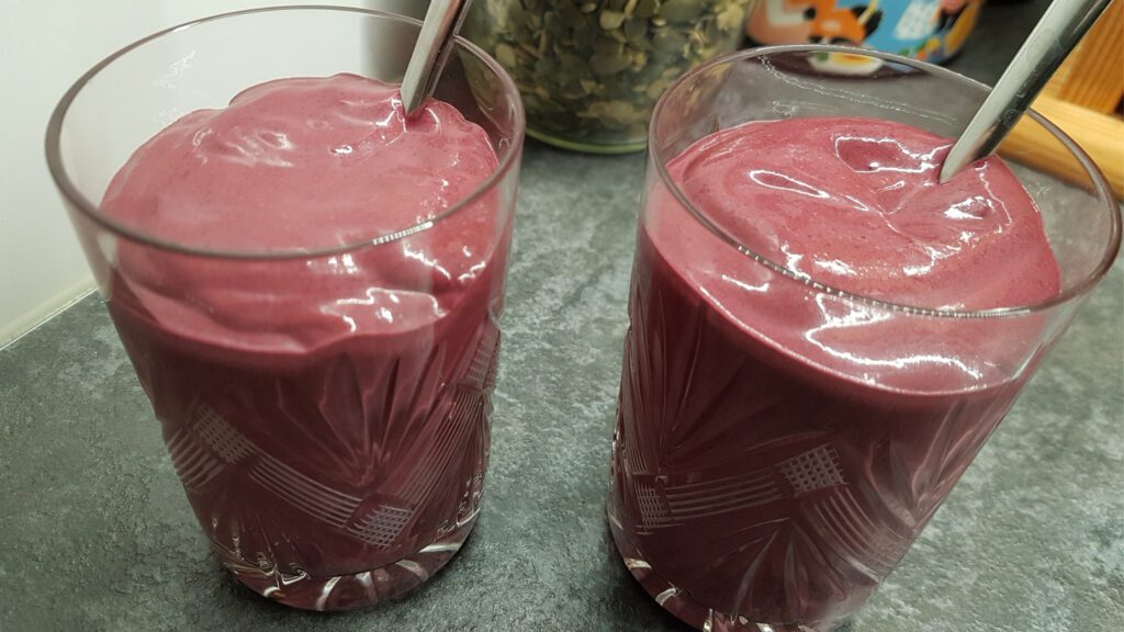 Kaks klaasi, milles on mustika-vaarika jogurt ja lusikad